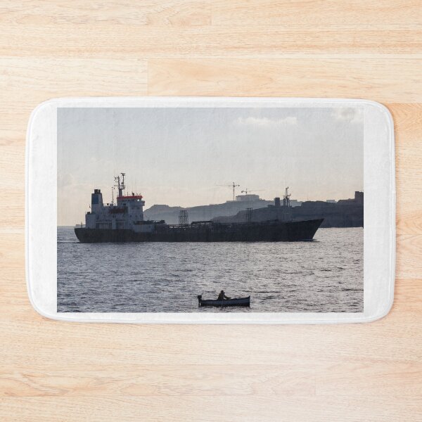 Item preview, Silhouette Cargo Ship and Small Rowboat on Calm Sea Near Coastal Construction at Dusk designed and sold by Nmallia.