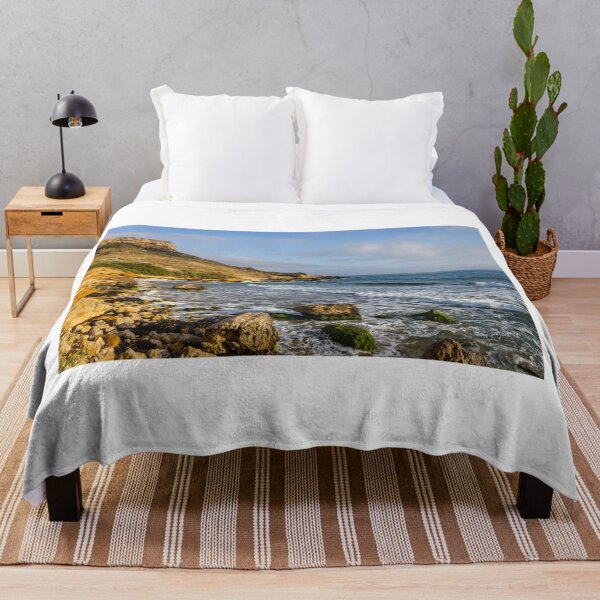 Item preview, Rocky Coastal Beach With Cliffs, Waves and Moss-Covered Boulders Under Blue Sky designed and sold by Nmallia.