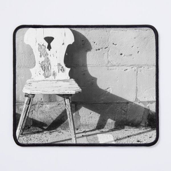 Item preview, Vintage Weathered Wooden Chair Casting Shadow Against Textured Stone Wall in Minimal Black and White designed and sold by Nmallia.
