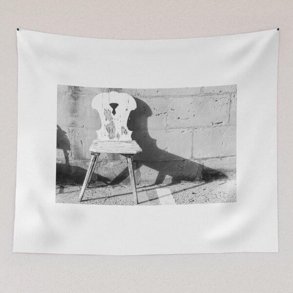 Item preview, Vintage Weathered Wooden Chair Casting Shadow Against Textured Stone Wall in Minimal Black and White designed and sold by Nmallia.