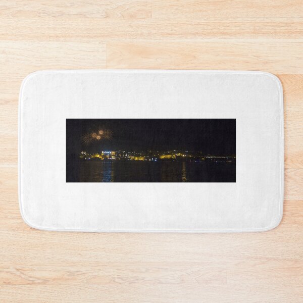 Item preview, Fireworks Over Coastal City At Night With Reflections On Calm Harbor Water And Illuminated Skyline designed and sold by Nmallia.