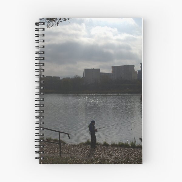 Item preview, Silhouette of a man fishing in a lake near an urban area on a cloudy day. designed and sold by FlorinWorks.