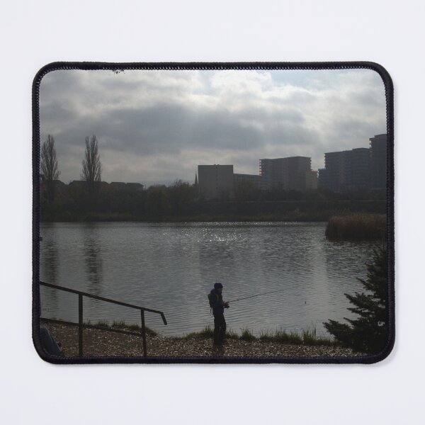 Item preview, Silhouette of a man fishing in a lake near an urban area on a cloudy day. designed and sold by FlorinWorks.