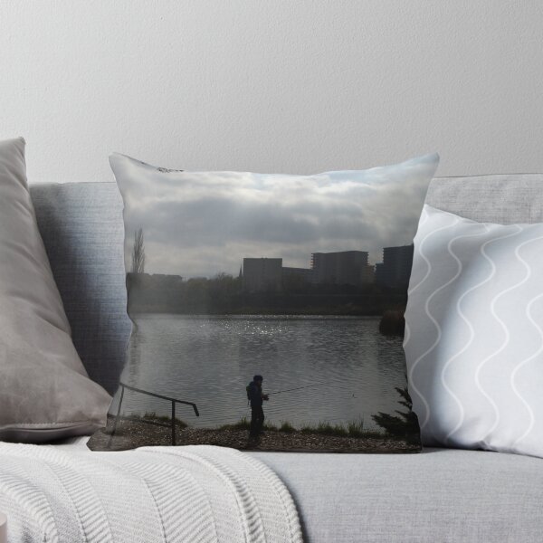 Item preview, Silhouette of a man fishing in a lake near an urban area on a cloudy day. designed and sold by FlorinWorks.