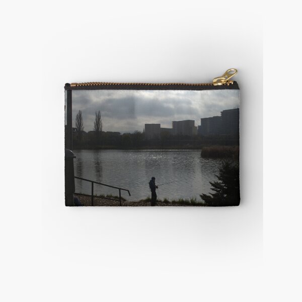 Item preview, Silhouette of a man fishing in a lake near an urban area on a cloudy day. designed and sold by FlorinWorks.