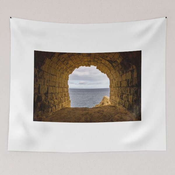 Item preview, Stone Arch Tunnel Framing A Calm Ocean View Over Rocky Coastal Cliff In Golden Light designed and sold by Nmallia.