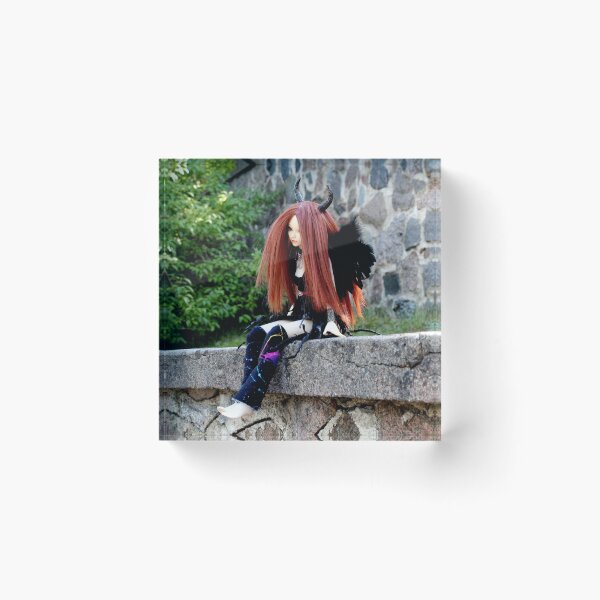Item preview, Devil doll sitting on a stone fence with green nature background designed and sold by Lenasminiland.
