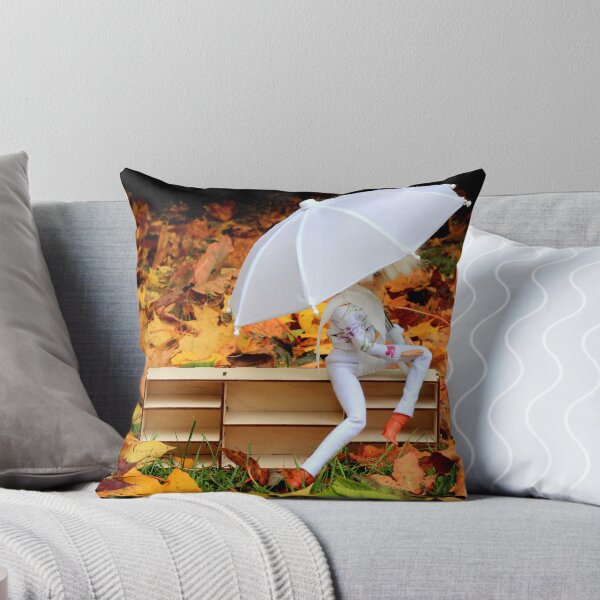Item preview, Doll with umbrella siting on bookcase with the background of yellow orange autumn leaves designed and sold by Lenasminiland.