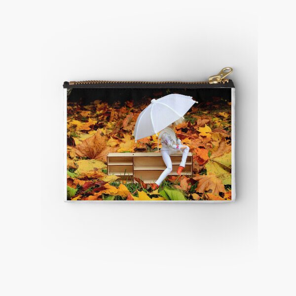 Item preview, Doll with umbrella siting on bookcase with the background of yellow orange autumn leaves designed and sold by Lenasminiland.