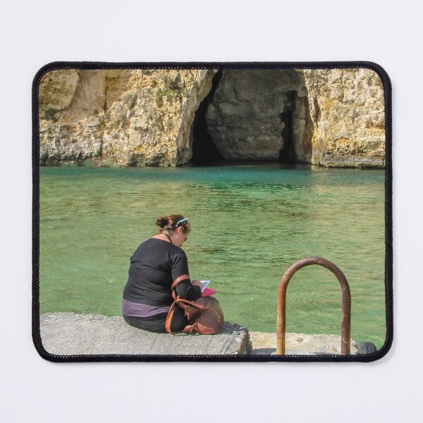 Item preview, Woman Reading On A Pier By Turquoise Water Near A Rocky Sea Cave And Sunlit Cliff designed and sold by Nmallia.