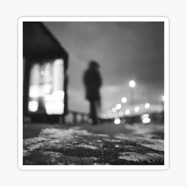 Man waiting at bus stop at night in winter square black and white analogue medium format film Hasselblad photo Sticker