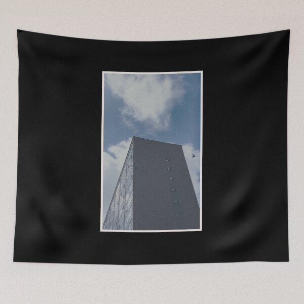 Item preview, bird swoops past a building on a day with a blue sky in glasgow (scotland) (may 2026) designed and sold by photosbykel.