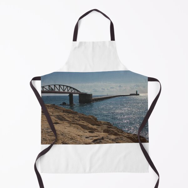 Item preview, Sunlit Rocky Coastline With Arched Bridge and Distant Lighthouse Over Sparkling Blue Sea designed and sold by Nmallia.