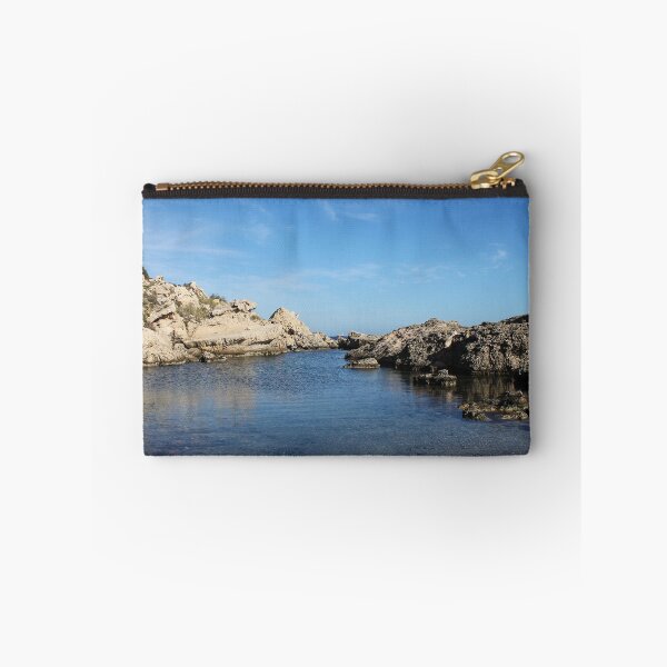Item preview, Sunlit Rocky Coastline With Clear Blue Water and Calm Sea Under A Bright Sky designed and sold by Nmallia.