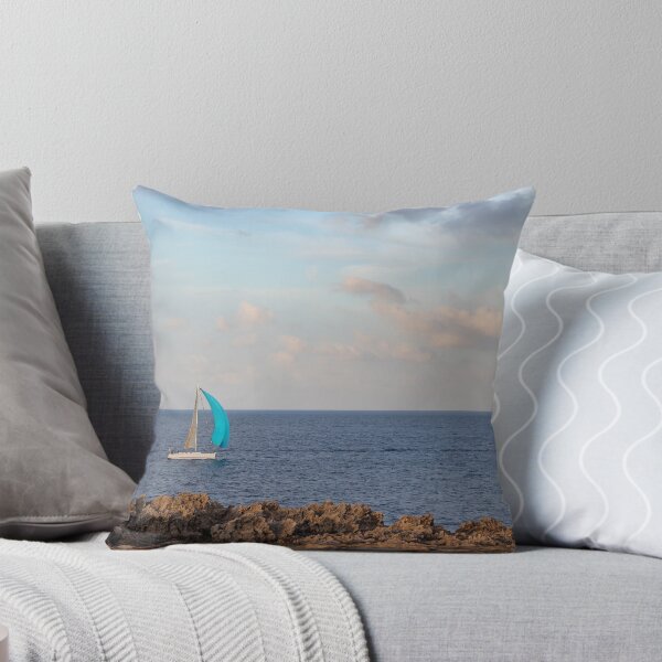 Item preview, Sailboat With Bright Blue Sail Cruising Near Rocky Shoreline Under Calm Sky And Open Horizon designed and sold by Nmallia.