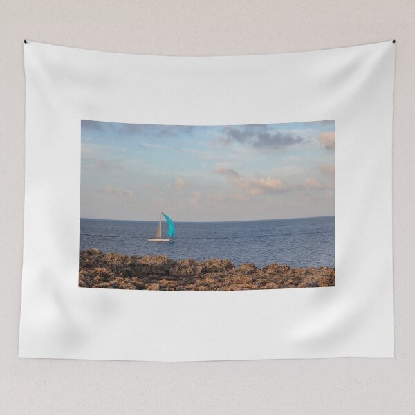 Item preview, Sailboat With Bright Blue Sail Cruising Near Rocky Shoreline Under Calm Sky And Open Horizon designed and sold by Nmallia.