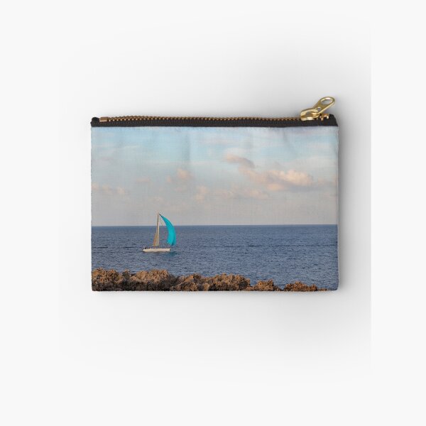 Item preview, Sailboat With Bright Blue Sail Cruising Near Rocky Shoreline Under Calm Sky And Open Horizon designed and sold by Nmallia.