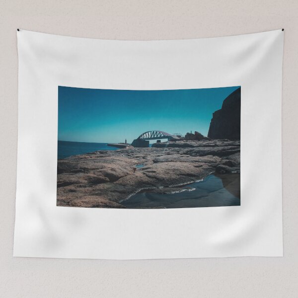 Item preview, Arched Bridge And Lighthouse Over Rocky Coastline At Calm Blue Sea During Clear Day designed and sold by Nmallia.