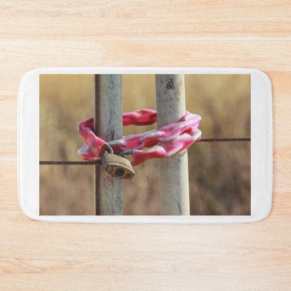 Item preview, Rusty Padlock Securing Pink Plastic-Wrapped Chain Around Metal Gate Posts With Shallow Focus designed and sold by Nmallia.