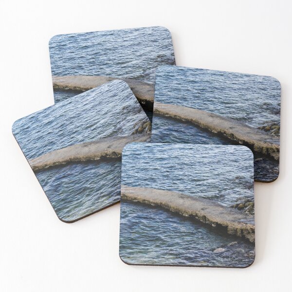 Item preview, Weathered Concrete Jetty Extending Over Rocky Shoreline Into Calm Blue Sea At Coast designed and sold by Nmallia.