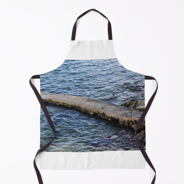 Item preview, Weathered Concrete Jetty Extending Over Rocky Shoreline Into Calm Blue Sea At Coast designed and sold by Nmallia.