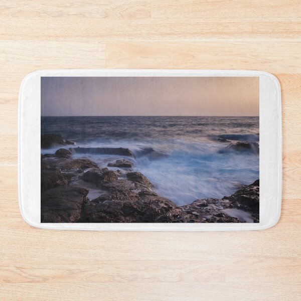 Item preview, Rocky Coastline With Waves Crashing Against Cliffs Near A Seaside Village At Dusk designed and sold by Nmallia.