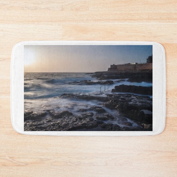 Item preview, Rocky Coastline With Waves Crashing Against Cliffs Near A Seaside Village At Dusk designed and sold by Nmallia.