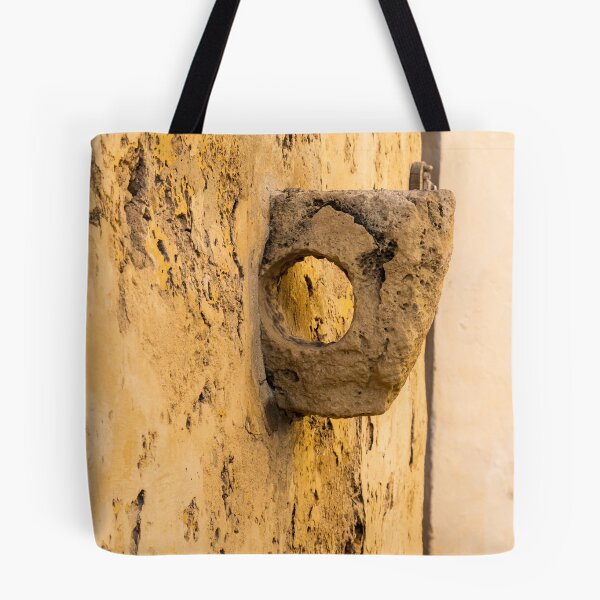 Item preview, Weathered Stone Wall With Circular Hole Detail On Ancient Yellow Plastered Architectural Facade designed and sold by Nmallia.