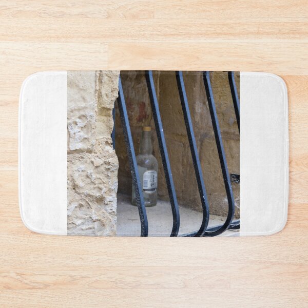Item preview, Abandoned Glass Bottle Behind Iron Bars In Stone Window Alcove In Urban Nook designed and sold by Nmallia.