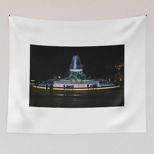 Item preview, Illuminated Night Fountain With Silhouetted People Gathered Around Water Feature in City Square designed and sold by Nmallia.