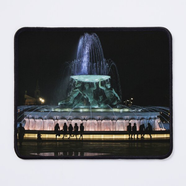 Item preview, Illuminated Night Fountain With Silhouetted People Gathered Around Water Feature in City Square designed and sold by Nmallia.