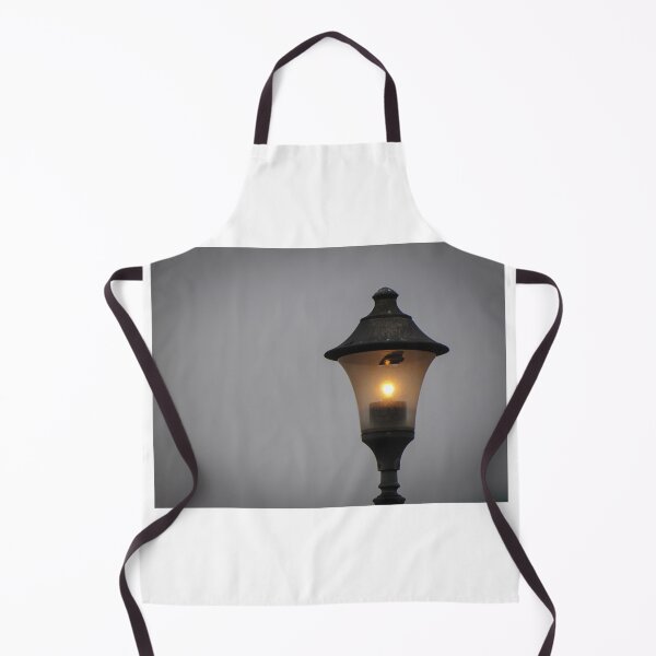 Item preview, Glowing Vintage Street Lamp at Dusk Casting Warm Light Against Overcast Sky designed and sold by Nmallia.