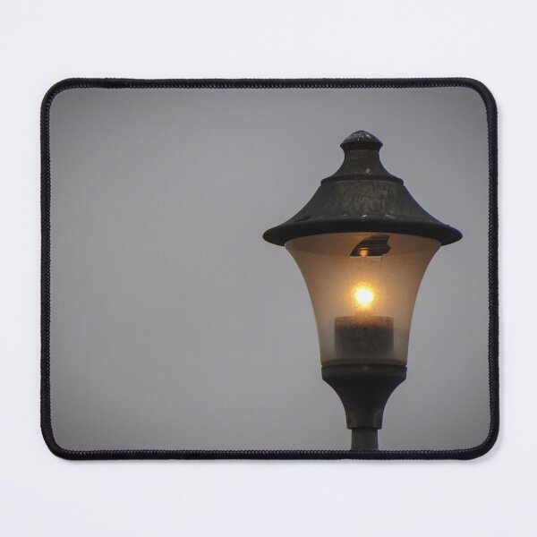 Item preview, Glowing Vintage Street Lamp at Dusk Casting Warm Light Against Overcast Sky designed and sold by Nmallia.
