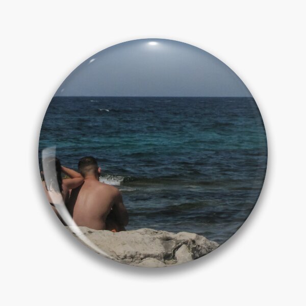 Item preview, Couple Sitting On Rocky Shoreline Looking Out At Blue Ocean Horizon On Summer Day designed and sold by Nmallia.