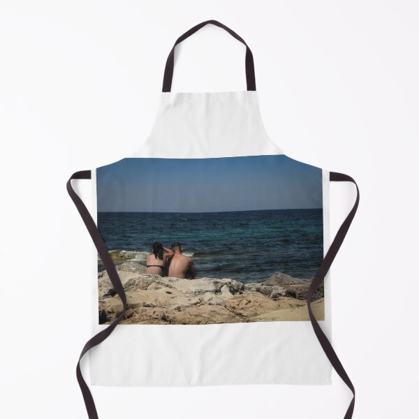 Item preview, Couple Sitting On Rocky Shoreline Looking Out At Blue Ocean Horizon On Summer Day designed and sold by Nmallia.