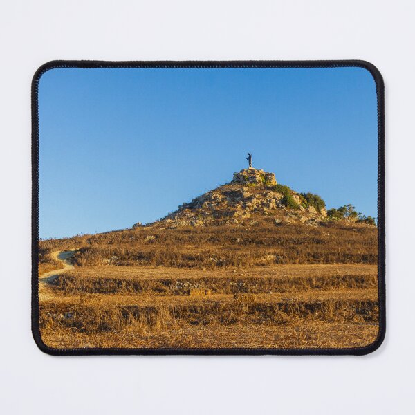 Item preview, Solitary Statue on Rocky Hill Overlooking Winding Trail Through Golden Dry Grass Under Blue Sky designed and sold by Nmallia.