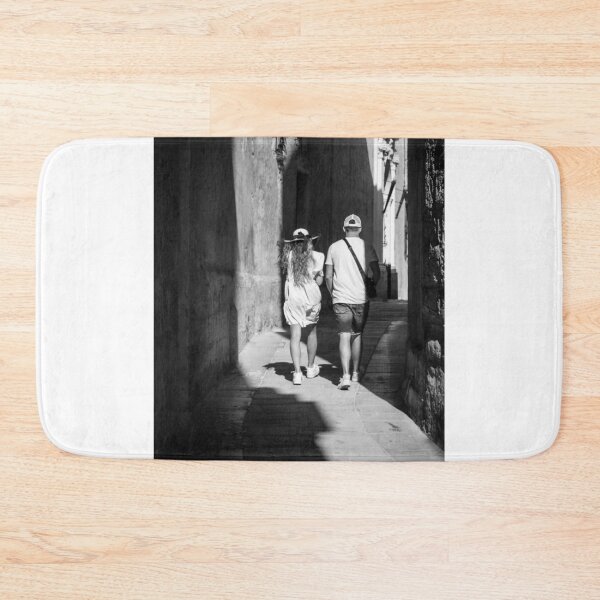 Item preview, Couple Walking Down Narrow Sunlit European Alleyway in Black and White Street Photography designed and sold by Nmallia.