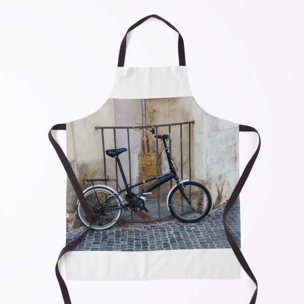 Item preview, Black Folding Bicycle Locked to Iron Rail on Cobblestone Street Beside Old Stone Wall designed and sold by Nmallia.