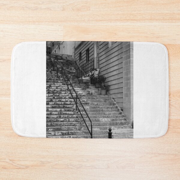 Item preview, Weathered Stone Steps With Iron Railing Beside Historic Urban Building In Monochrome designed and sold by Nmallia.