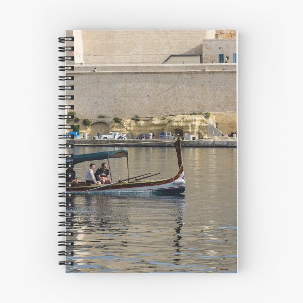 Item preview, Traditional Maltese Dgħajsa Boat Carrying Tourists Along Valletta Harbour With Limestone Fortifications designed and sold by Nmallia.