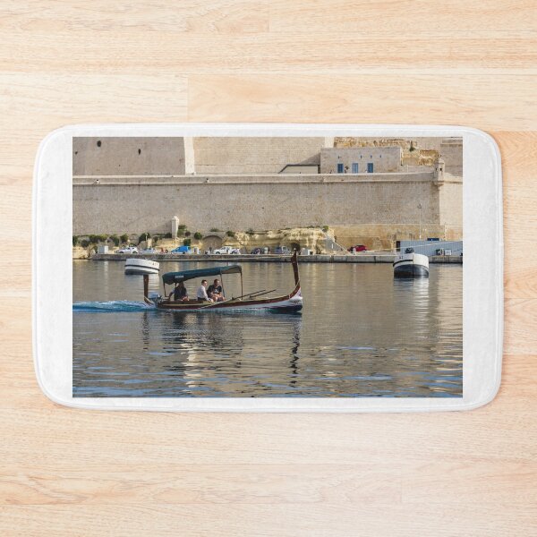 Item preview, Traditional Maltese Dgħajsa Boat Carrying Tourists Along Valletta Harbour With Limestone Fortifications designed and sold by Nmallia.