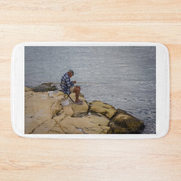Item preview, Elderly Man Fishing On Rocky Shore With Long Rod And Buckets At Calm Sea designed and sold by Nmallia.