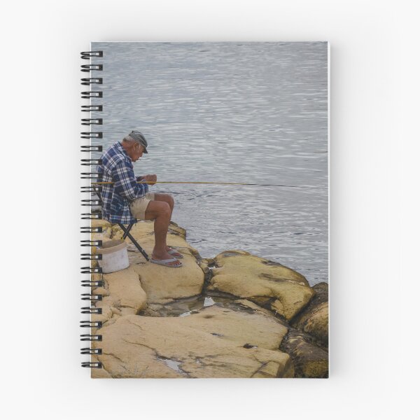 Item preview, Elderly Man Fishing On Rocky Shore With Long Rod And Buckets At Calm Sea designed and sold by Nmallia.