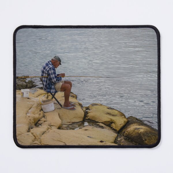 Item preview, Elderly Man Fishing On Rocky Shore With Long Rod And Buckets At Calm Sea designed and sold by Nmallia.
