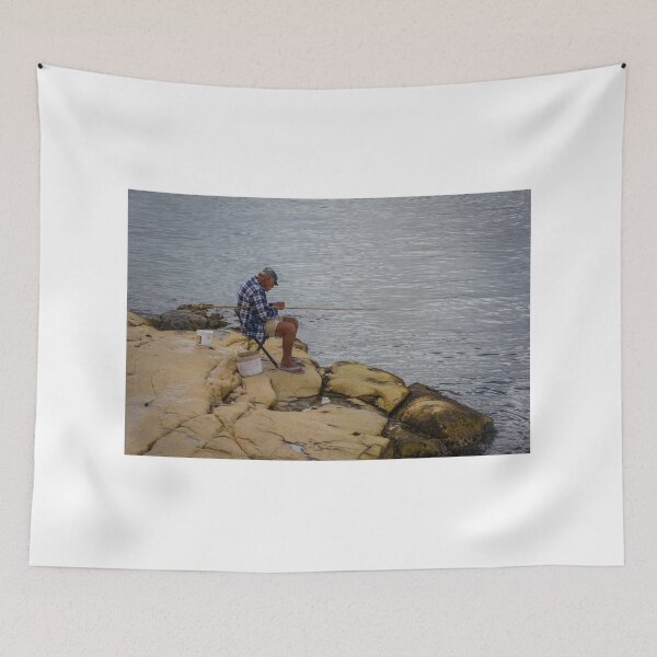 Item preview, Elderly Man Fishing On Rocky Shore With Long Rod And Buckets At Calm Sea designed and sold by Nmallia.