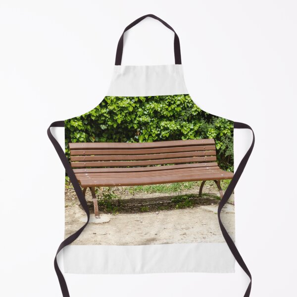Item preview, Empty Wooden Park Bench Against Ivy Hedge in Sunny Outdoor Garden Seating Area for Relaxation designed and sold by Nmallia.