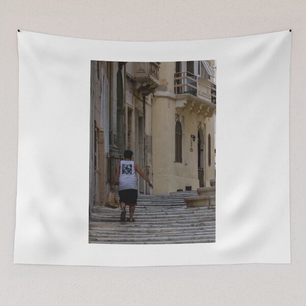 Item preview, Man Walking Up Historic Stone Steps Through Narrow Old Town Street With Warm Mediterranean Architecture designed and sold by Nmallia.