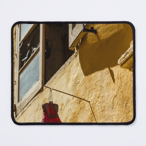 Item preview, Red Cowboy Boot Hanging From Rustic Window Above Sunlit Yellow Stucco Wall designed and sold by Nmallia.