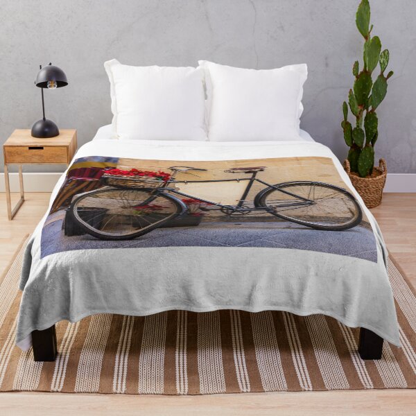 Item preview, Vintage Bicycle With Wicker Basket of Red Poinsettias Leaning Against Rustic Wall on Street designed and sold by Nmallia.