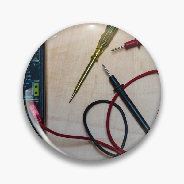 Artikelvorschau, Digitales Multimeter mit roten und schwarzen Messspitzen und Schraubendreher auf einer Holzwerkbank für Elektronikmessungen und -reparaturen entworfen und verkauft von Nmallia.